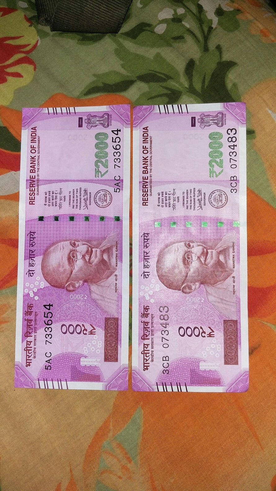 Two Indian 2000 Rupee Banknotes Featuring Mahatma Gandhi Portrait on Floral Fabric Background HD phone wallpaper