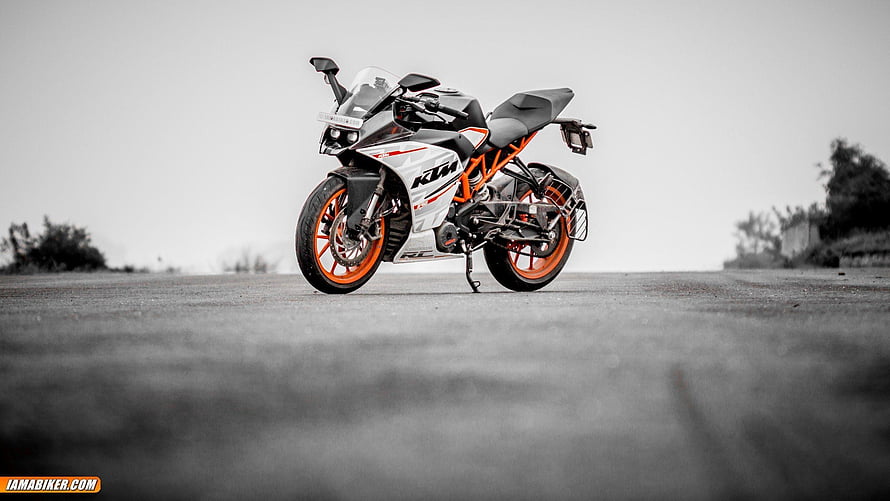 KTM RC sport motorcycle with orange wheels parked on an open asphalt road HD wallpaper