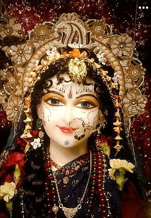 Beautifully adorned Hindu goddess statue with intricate jewelry, floral garlands, and traditional makeup HD phone wallpaper