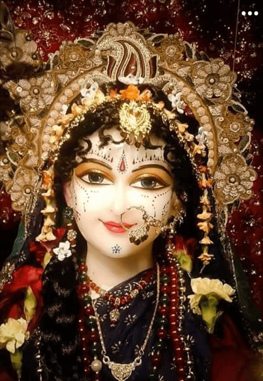 Beautifully adorned Hindu goddess statue with intricate jewelry, floral garlands, and traditional makeup HD phone wallpaper