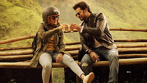 Hrithik Roshan and Radhika Madan sharing a drink on a bamboo bench in a scenic mountain setting HD wallpaper