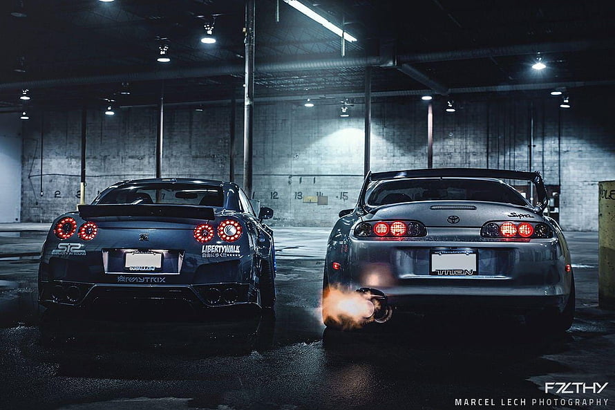 Nissan GT-R and Toyota Supra Rear View in Dark Garage with Exhaust Flames HD wallpaper