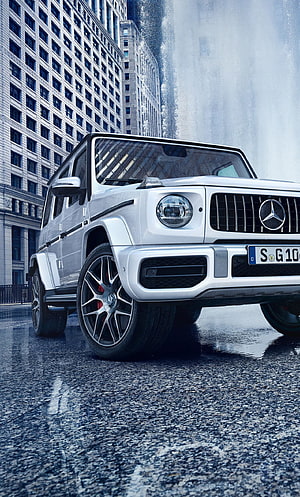 White Mercedes-AMG G63 SUV parked on wet city street with skyscrapers HD phone wallpaper