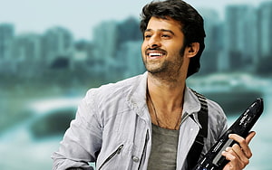 Prabhas in Mirchi Movie Holding Guitar with City Skyline Background HD wallpaper