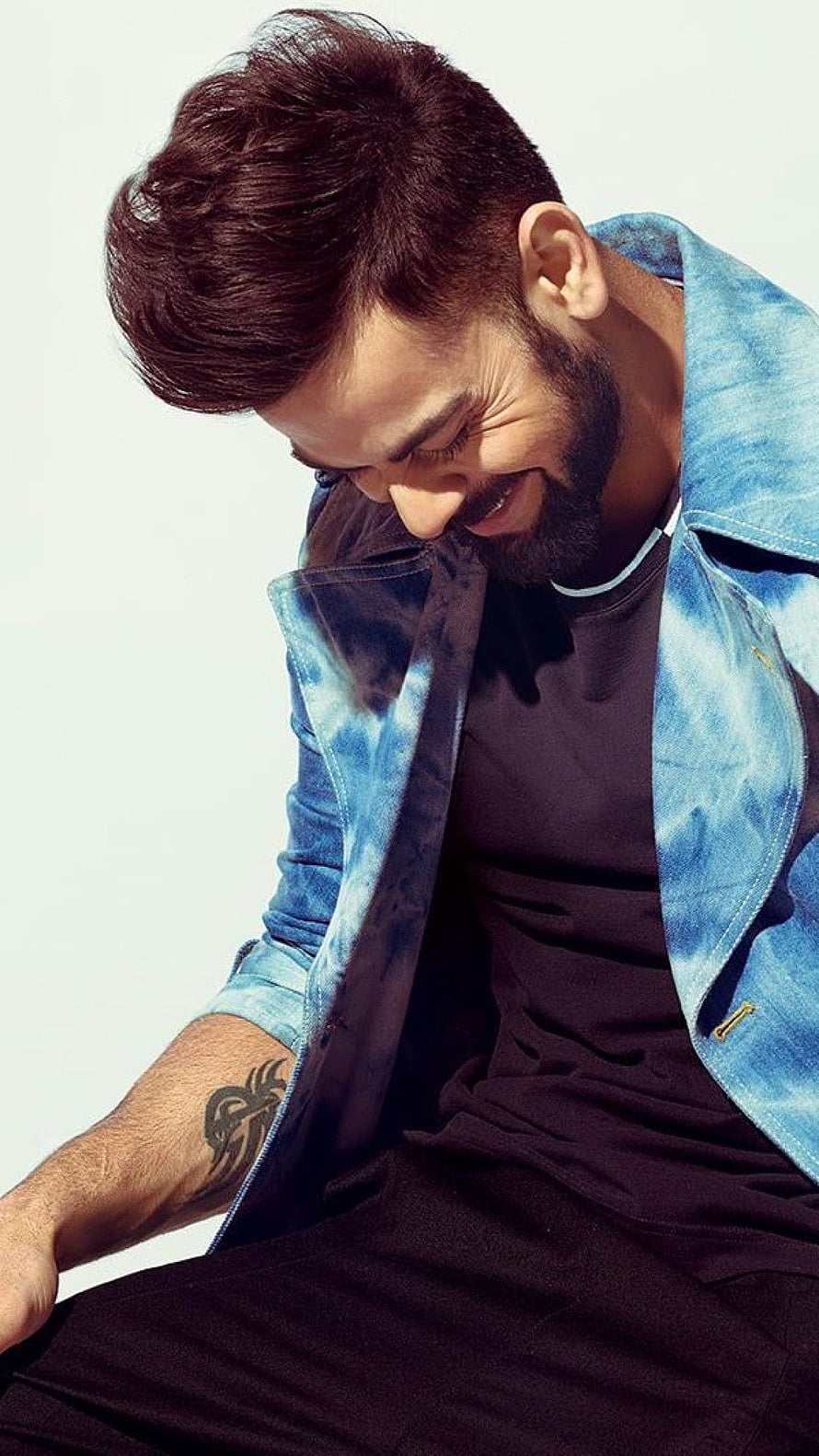 Virat Kohli smiling in a blue denim jacket with a black t-shirt and visible arm tattoo HD phone wallpaper