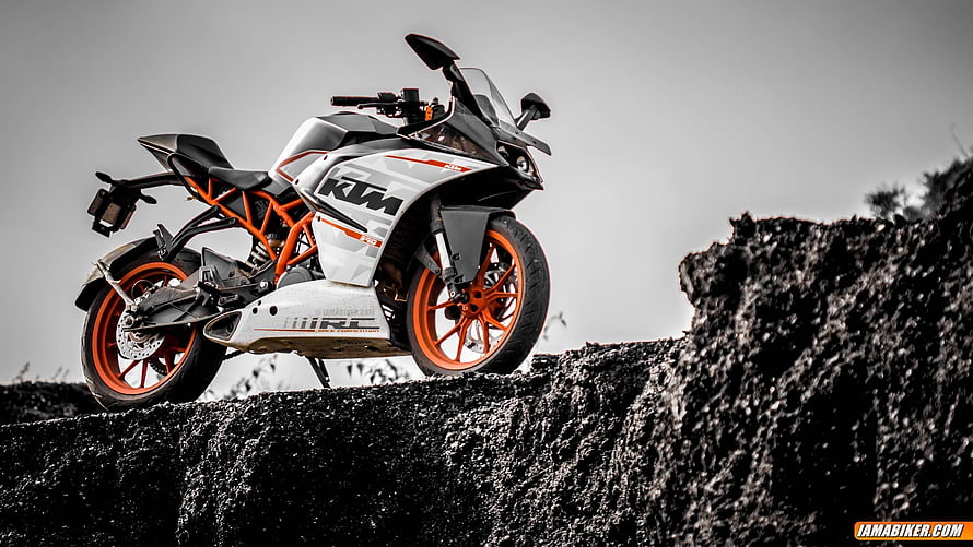 KTM RC 390 Sportbike Perched on Rocky Outcrop with Orange Frame and Wheels HD wallpaper