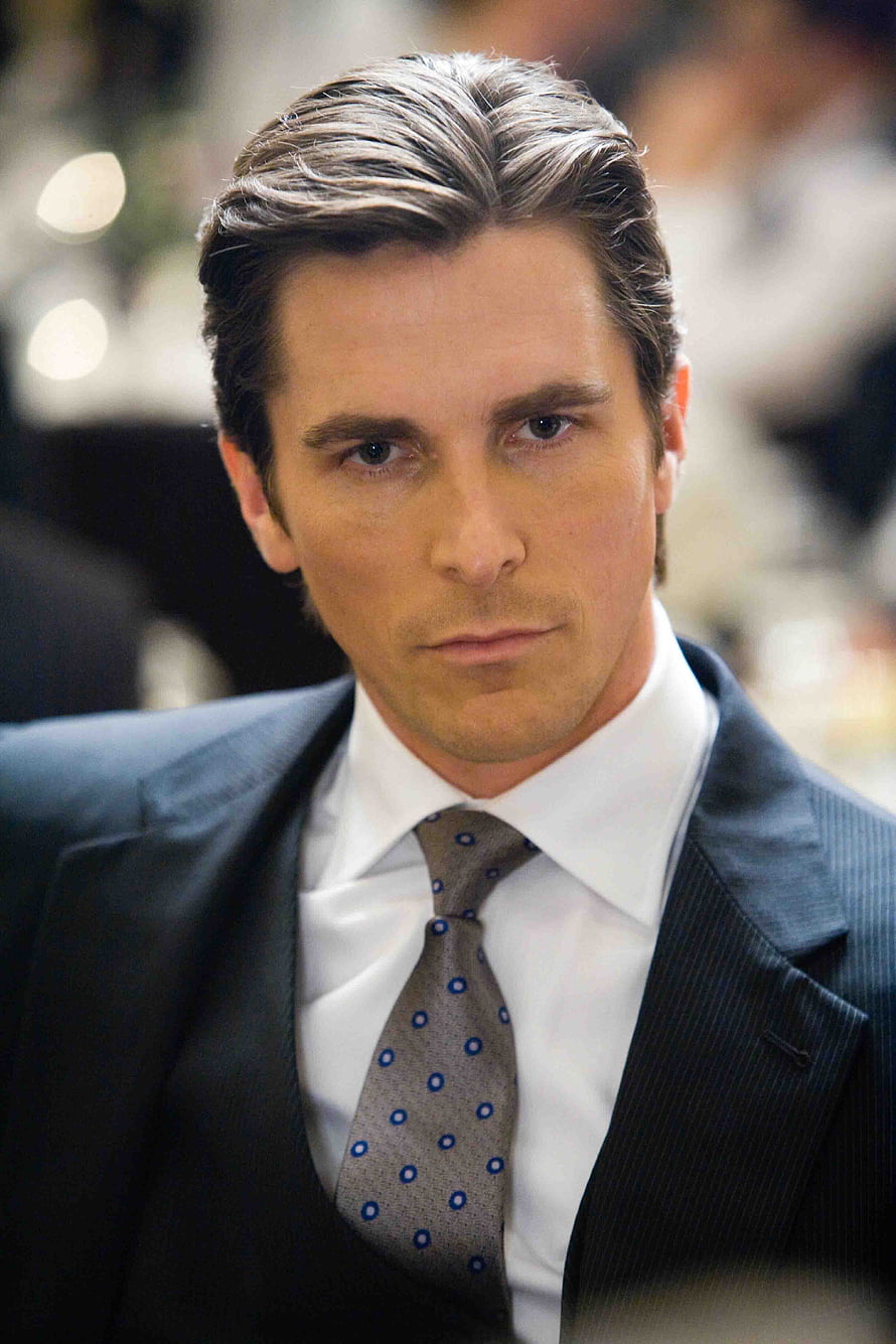 Christian Bale in a dark pinstripe suit with a patterned tie and a serious expression HD phone wallpaper
