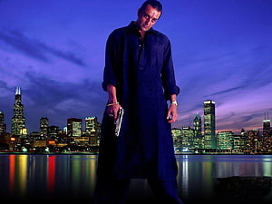 Sanjay Dutt in a dark robe holding a pistol against a Chicago skyline at dusk HD wallpaper