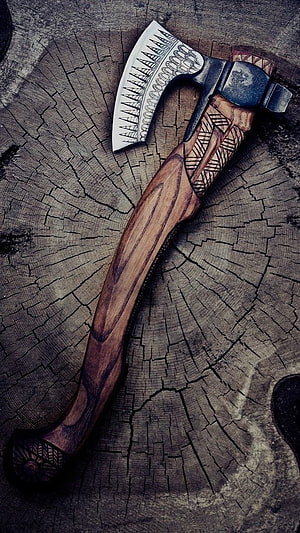 Handcrafted Viking Axe with Intricate Engraved Patterns on Weathered Wood HD phone wallpaper