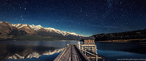 Starry Night Over Snow-Capped Mountains and a Wooden Lake Pier HD wallpaper