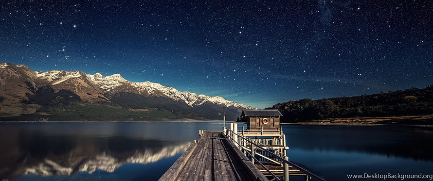 Starry Night Over Snow-Capped Mountains and a Wooden Lake Pier HD wallpaper