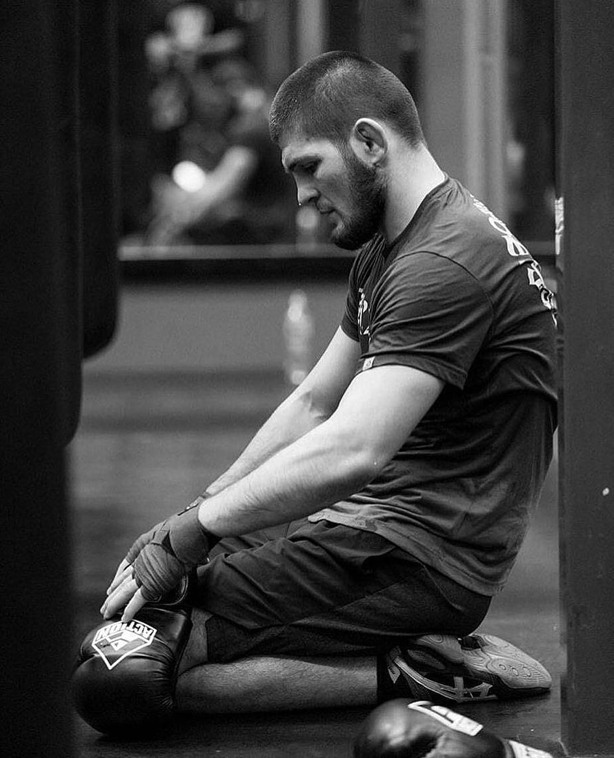 Black and white portrait of Khabib Nurmagomedov sitting on gym floor with boxing gloves HD phone wallpaper