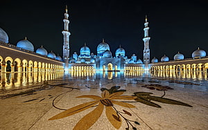 Sheikh Zayed Grand Mosque illuminated at night with blue domes and golden courtyard mosaic HD wallpaper