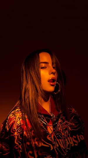 Billie Eilish in Dramatic Red Lighting Wearing Graphic Hoodie and Layered Jewelry HD phone wallpaper
