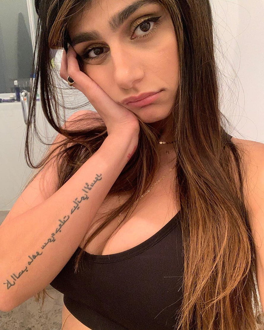 Woman with long brown hair and Arabic script tattoo on forearm posing in black top, Mia Khalifa Latest , And, mia khalifa mobile HD phone wallpaper