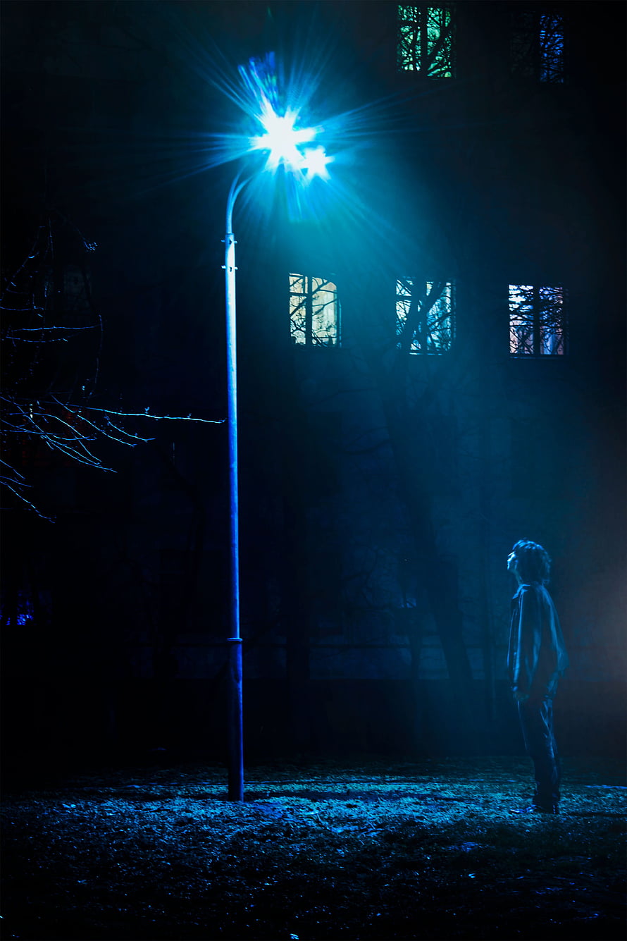 Lonely Figure Standing Under Bright Blue Streetlight at Night HD phone wallpaper