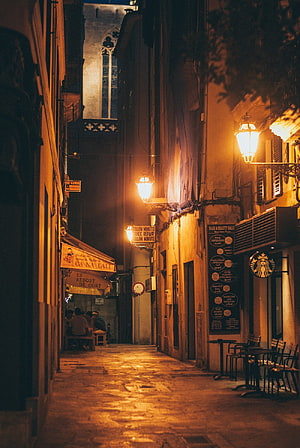 Atmospheric Night View of a Narrow European Street with Warm Streetlights and Cobblestones HD phone wallpaper