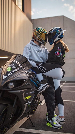 Couple in Motorcycle Helmets Embracing Next to Sport Bike HD phone wallpaper