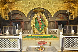 Sai Baba Shrine at Shirdi Temple with Golden Carvings and Floral Offerings HD wallpaper