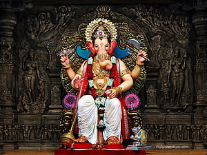 Lord Ganesha Statue with Axe and Lotus in Ornate Temple Setting HD wallpaper