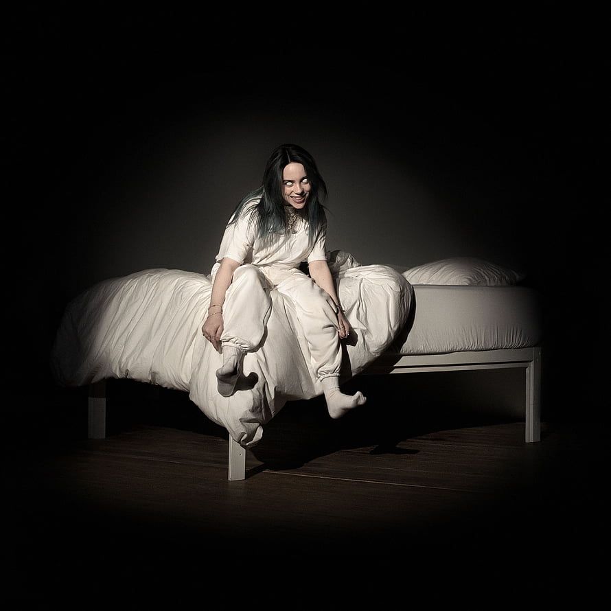 Billie Eilish in White Outfit Sitting on Bed in Dramatic Dark Studio Lighting HD phone wallpaper