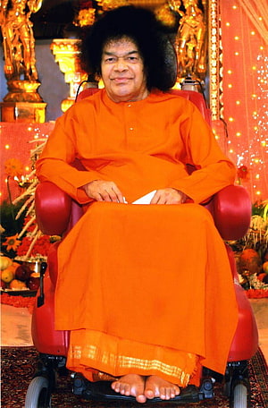 Sathya Sai Baba Seated in a Red Wheelchair Wearing Traditional Orange Robes HD phone wallpaper