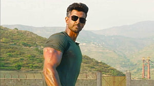 Hrithik Roshan in Tiger 3 wearing sunglasses and green t-shirt with muscular arms against mountain backdrop HD wallpaper