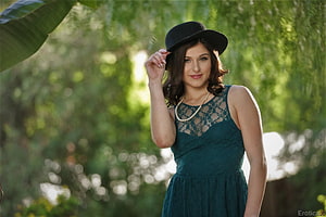 Leah Gotti in a teal lace dress and black hat posing in a sunlit garden HD wallpaper