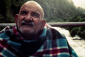 Neem Karoli Baba Portrait in Plaid Shawl by a River HD wallpaper