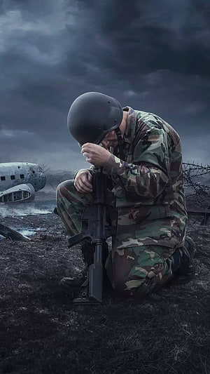 Grieving Soldier Kneeling on a Dark Battlefield with Crashed Aircraft HD phone wallpaper