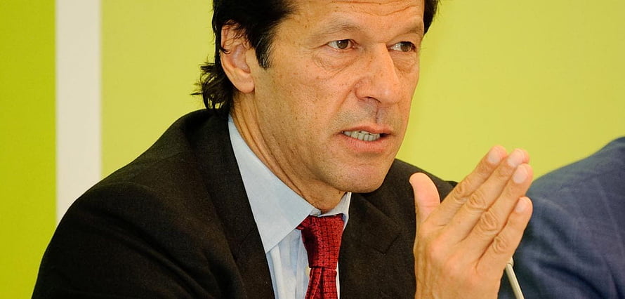 Imran Khan Speaking at a Press Conference in a Dark Suit and Red Tie HD wallpaper