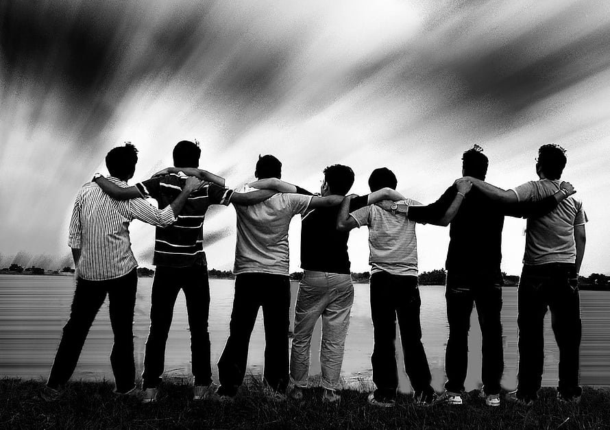 Black and white photo of seven friends standing with arms around each other by a lake HD wallpaper