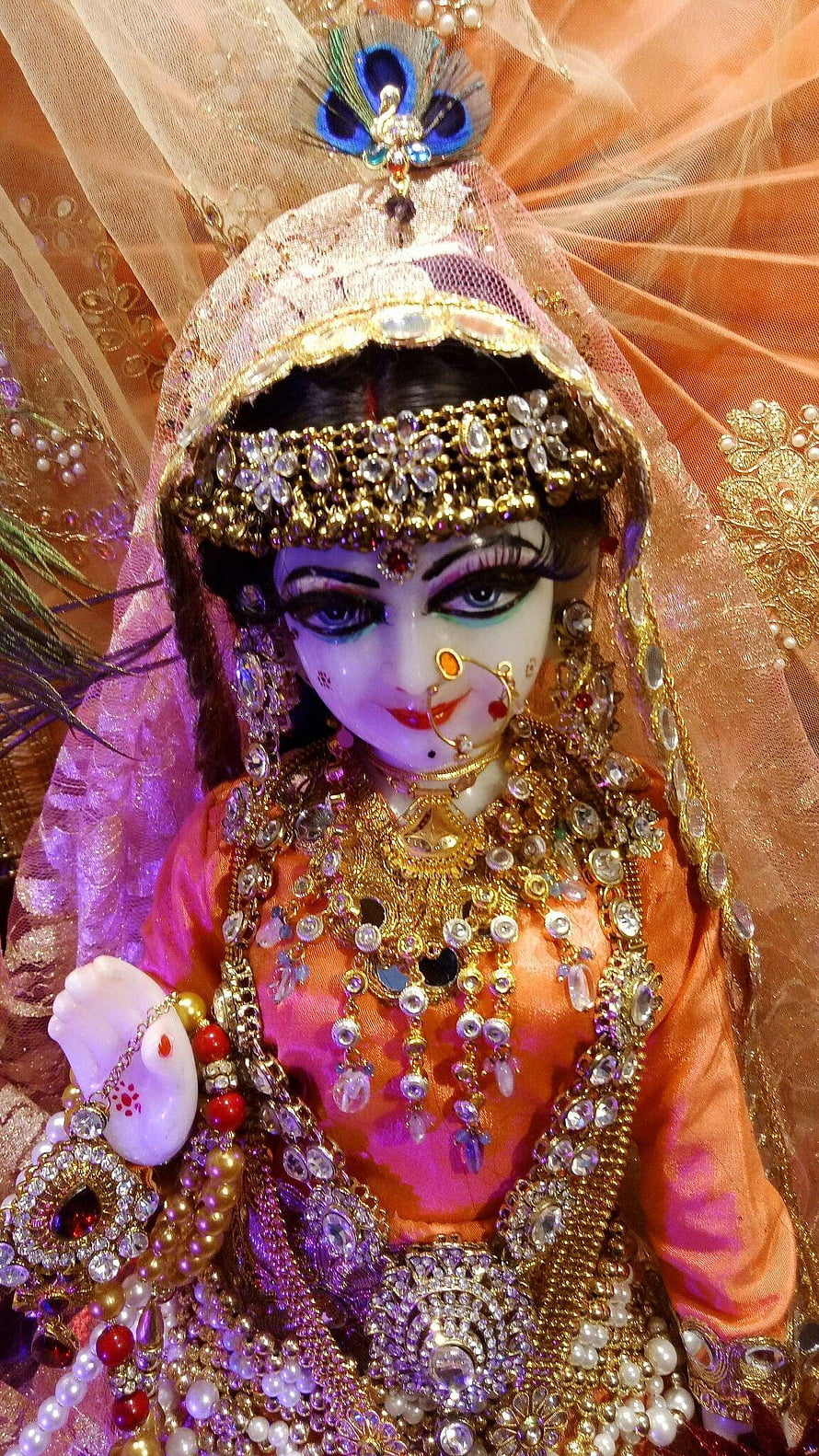 Ornate Radha Rani Doll in Traditional Indian Bridal Attire with Gold Jewelry and Peacock Crown HD phone wallpaper