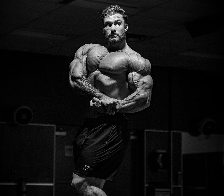 Chris Bumstead Classic Physique Pose in Dramatic Black and White Gym Lighting HD wallpaper