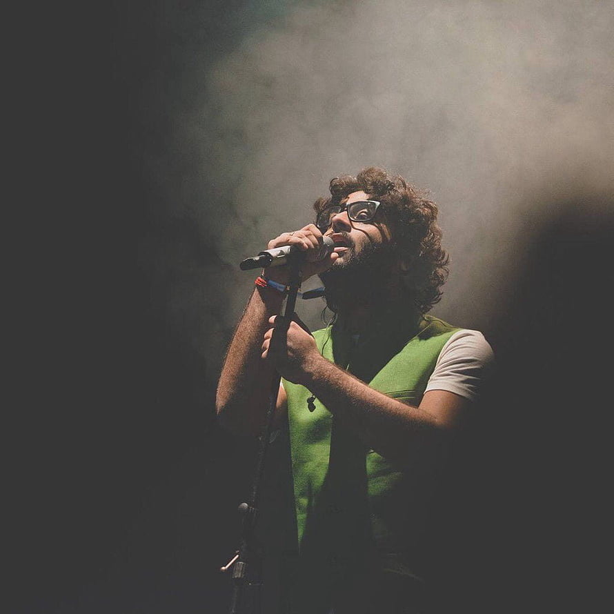 Male Singer Performing on Stage with Microphone in Smoky Atmosphere HD phone wallpaper