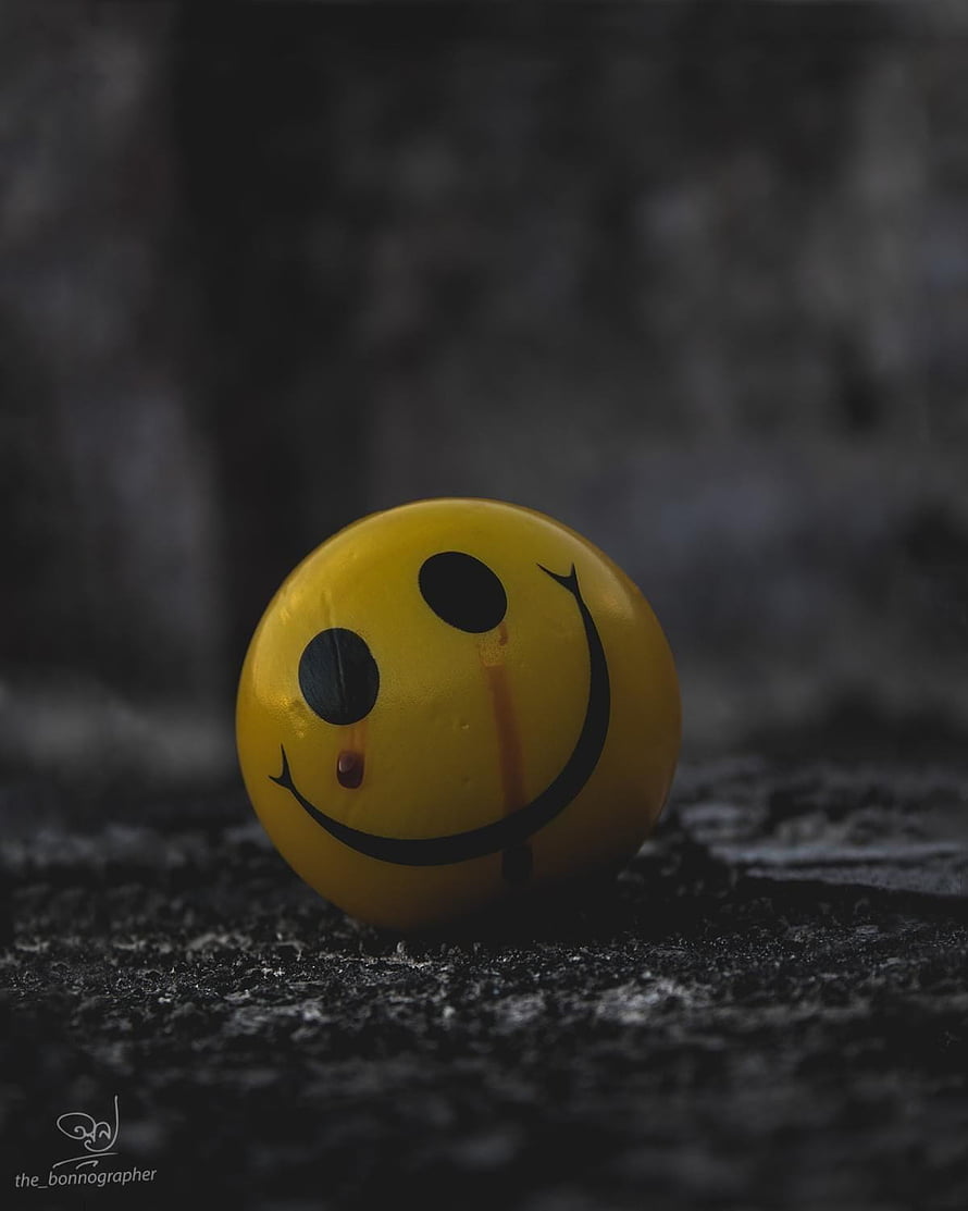 Crying Yellow Smile Ball on Dark Textured Surface HD phone wallpaper