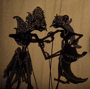 Traditional Indonesian Wayang Kulit Shadow Puppet Performance with Intricate Carved Figures HD wallpaper