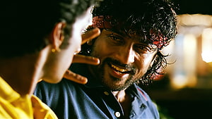 Surya in a warm cinematic close-up with a red bandana and playful expression HD wallpaper