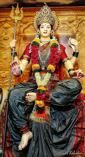 Lord Shiva Statue Holding Trishul and Damru with Flower Garlands HD phone wallpaper