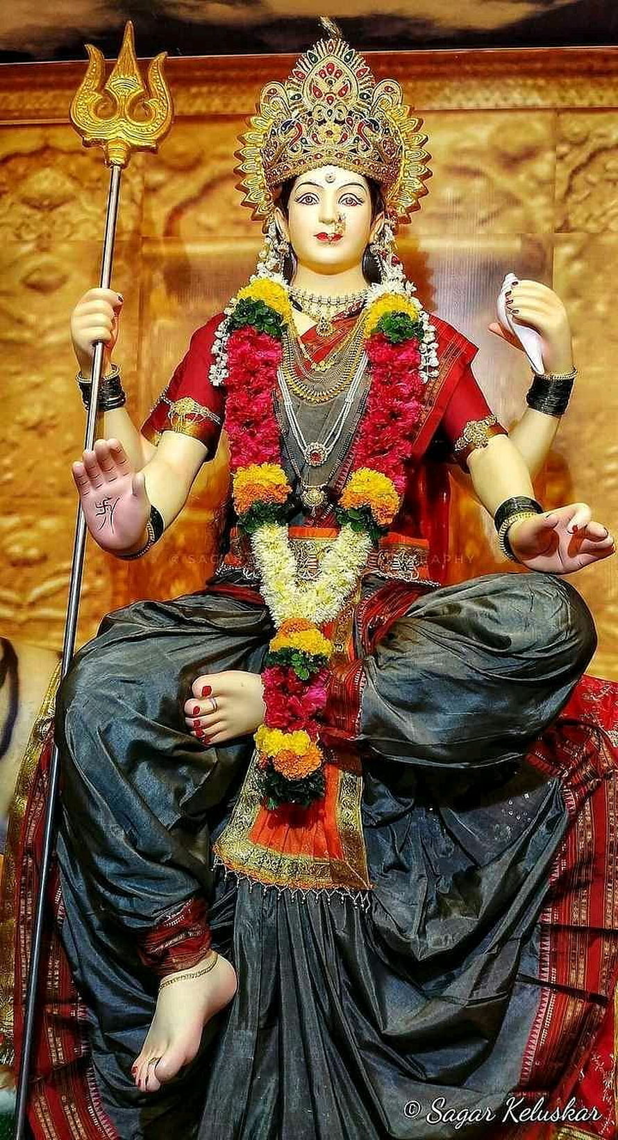 Lord Shiva Statue Holding Trishul and Damru with Flower Garlands HD phone wallpaper
