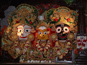 Traditional Jagannath Temple Deities with Ornate Crowns and Floral Offerings HD wallpaper