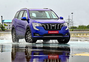 Blue Mahindra XUV700 SUV Driving Through Water Splash On Wet Road HD wallpaper