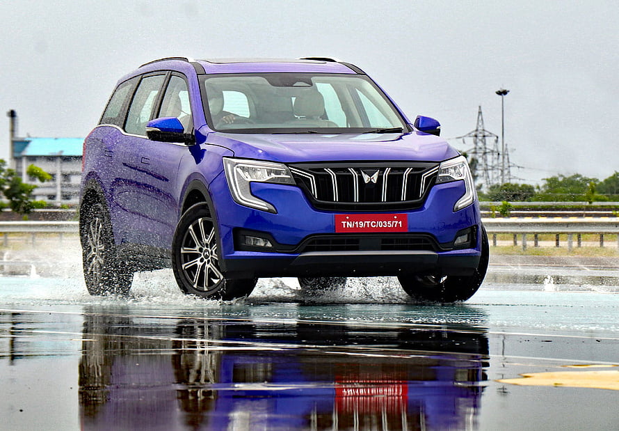 Blue Mahindra XUV700 SUV Driving Through Water Splash On Wet Road HD wallpaper