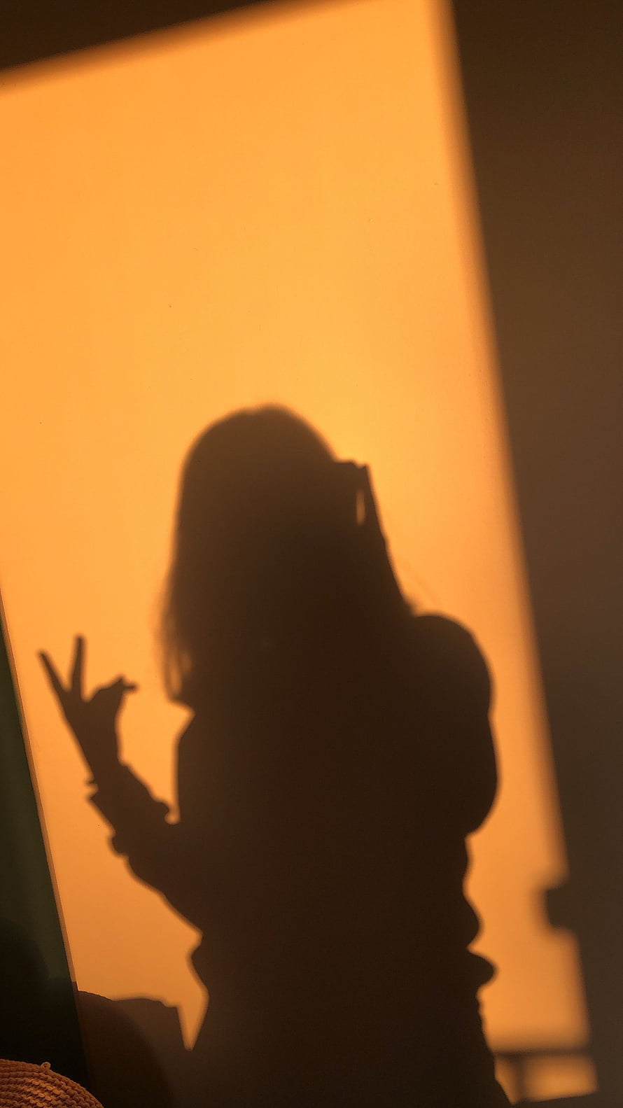 Warm Golden Shadow of a Girl Making a Peace Sign on a Wall HD phone wallpaper