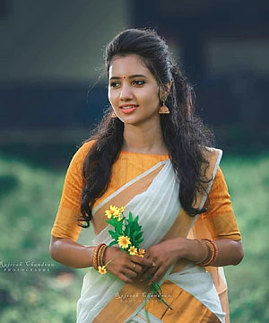 Young Indian woman in a yellow and white saree holding a small bouquet of marigold flowers, of Indian Girls in Saree ...in.pinterest, girl saree HD phone wallpaper