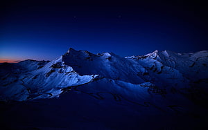 Snowy Mountain Peaks at Twilight with Winding Road and Deep Blue Sky HD wallpaper