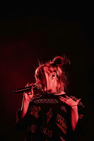 Billie Eilish performing live on stage with dramatic red lighting and microphone HD phone wallpaper