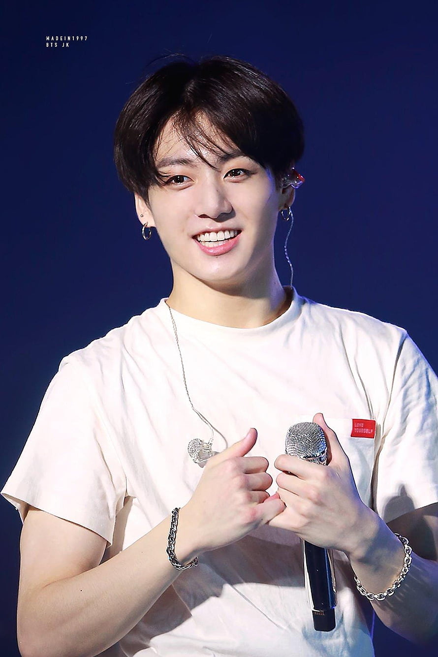 Stunning Portrait of BTS Member Jungkook Smiling on Stage in White T-Shirt HD phone wallpaper