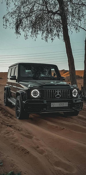 Black Mercedes-AMG G63 Driving on Sandy Desert Dunes Under Trees HD phone wallpaper