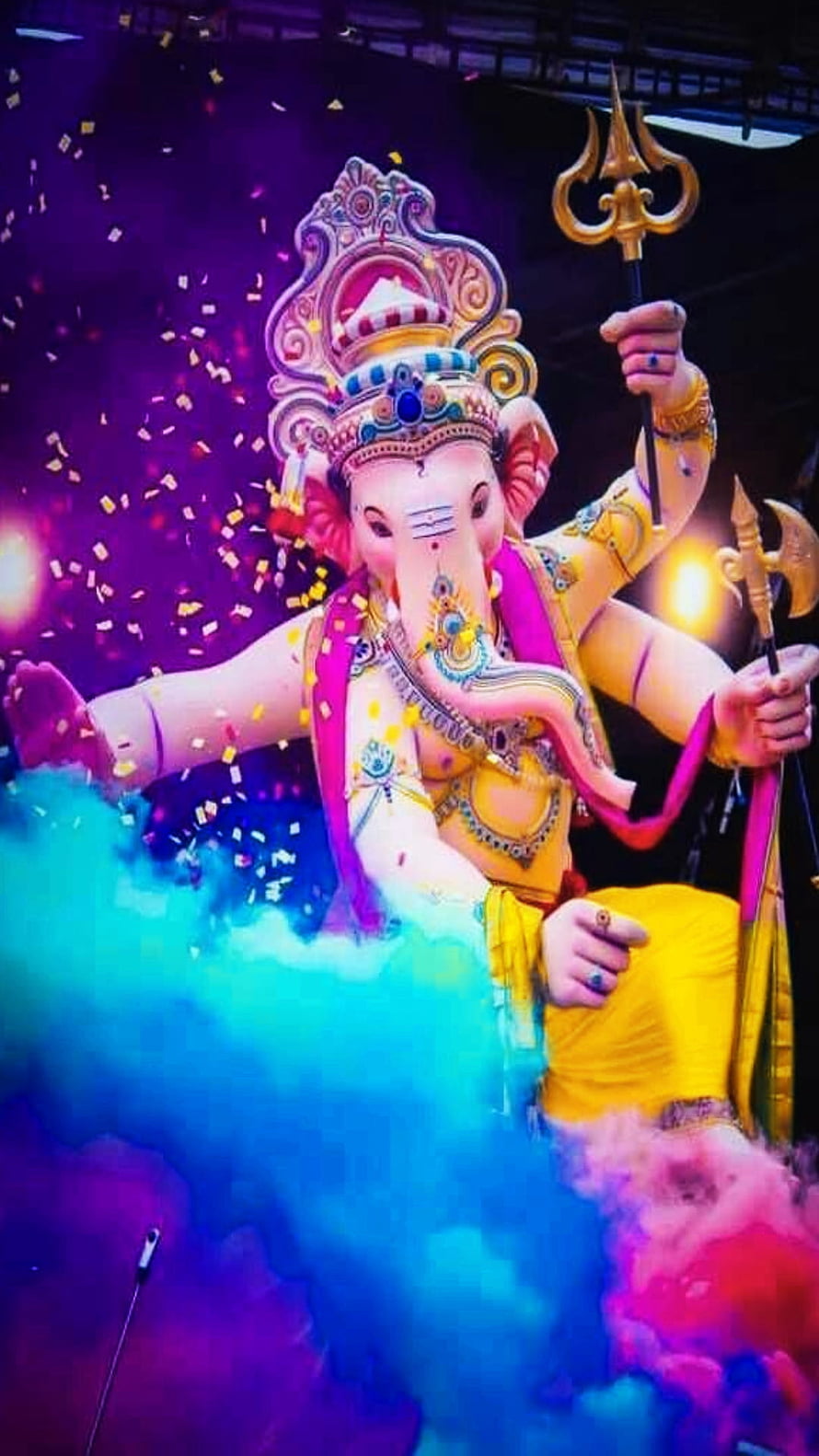 Vibrant Ganesha Idol with Trishul and Axe Amidst Colorful Smoke and Confetti HD phone wallpaper